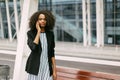 Close-up horizontal portrait of the beautiful serious afro-american girl talking via the mobile phone. Royalty Free Stock Photo