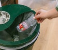 Hand dropping a plastic bottle into a recycling bin Royalty Free Stock Photo