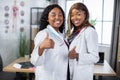 Two pretty gorgeous Afro American women physicians, posing with smile and thumbs up to camera Royalty Free Stock Photo