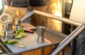 Close-Up, Horizontal Shot of a Wooden and Metal Bar Cart with Cocktail Making Tools and Lime Wedges, Captured from a Slightly Royalty Free Stock Photo