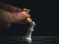 Close-up horse, golden knight chess piece attack the silver queen on chessboard on dark background. Royalty Free Stock Photo