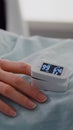 Close up of hospitalized woman with finger heart rate monitor showing pulse Royalty Free Stock Photo