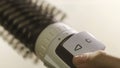 Close up of hot air rotating hair styler in female hands. Concept. Woman hands showing the work of air dryer isolated on Royalty Free Stock Photo