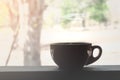 Close up of Hot brown coffee black cup with smoke on wood table and view of trees nature. Royalty Free Stock Photo