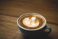 Close up hot cappuccino coffee cup with heart shape latte art on wood table at cafe,Drak tone filter,food and drink Royalty Free Stock Photo