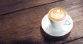 Close up hot cappuccino white coffee cup with heart shape latte art on dark brown old wood table at cafe,food and drink concept