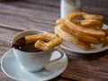 Close-up of a hot chocolate cup next to a churros dish Royalty Free Stock Photo