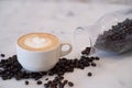 Close-up of Hot coffee latte with latte art milk foam in cup or mug on desk with coffee beans in coffee shop at the cafe business Royalty Free Stock Photo