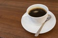 Close up hot espresso with bubbles in white coffee cup on wood table near window in coffee shop in the morning in vintage soft Royalty Free Stock Photo
