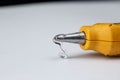 Close-up of hot glue coming out of a glue gun. Hot glue is squeezed out of the gun