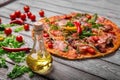 A close-up of hot margarita pizza on a rustic table background. Whole Italian pizza with vegetables and olive oil. Royalty Free Stock Photo