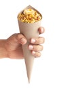 Close-Up of Hot spicy Nav Ratan snacksin brown paper cone holding in hand isolated over white