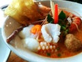 Close up hot spicy seafood noodle squid, shrimp, fish ball, and Eggs onsen with soup on the white bowl Royalty Free Stock Photo