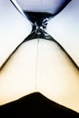 Close-up of an hourglass with sand falling through silhouette Royalty Free Stock Photo