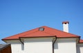 Close up on house attic skylight window with red metal roof, gutter, chimney Royalty Free Stock Photo