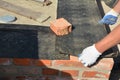 Close up on house foundation wall construction with builder contactor laying waterproofing membrane. House foundation waterprofing