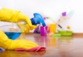 Housekeeper spraying detergent on parquet and wiping