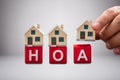 Person Placing The Miniature Houses On Red Hoa Blocks Royalty Free Stock Photo