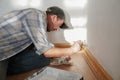 Close up of the house painter. Man, painting a wall with white paint and a paint roller or brush. Selective focus Royalty Free Stock Photo