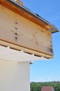 Close up on house roofing construction with soffit boards installation. Unfinished fascia board