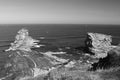 Close up of huge cliff rocks of deux jumeaux in atlantic ocean with waves in black and white Royalty Free Stock Photo