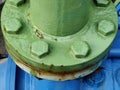 Close up of a huge green industrial pipe with bolts