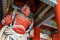 A large red wooden statue of a protector deity at a Japanese temple gate