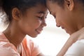 Close up of hugging african mother and daughter touching foreheads Royalty Free Stock Photo