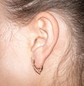 Close up of human ear with gold earring in earring Royalty Free Stock Photo