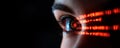 Close up of human eye with glowing binary code, symbolizing technology