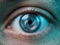 Close-up of human eye with mechanical camera shutter iris, representing surveillance technology, biometric security and cybernetic Royalty Free Stock Photo