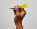 Close up of human hand holding dart on white background Royalty Free Stock Photo