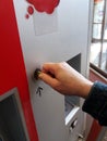 Close-up of human hand inserting coin in vending machine Royalty Free Stock Photo