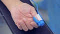 Close up of a human hand lying on an arm board with a sensing device connected to it