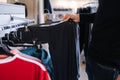 Close-up of human hand take clothes to try on. Male hand take pajamas in clothing store Royalty Free Stock Photo