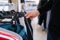 Close-up of human hand take clothes to try on. Male hand take pajamas in clothing store Royalty Free Stock Photo