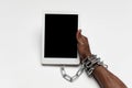 Close up of human hand using tablet with blank black screen. Tied with chain, addiction Royalty Free Stock Photo