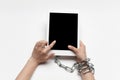 Close up of human hand using tablet with blank black screen. Tied with chain, addiction Royalty Free Stock Photo