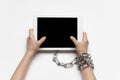 Close up of human hand using tablet with blank black screen. Tied with chain, addiction Royalty Free Stock Photo