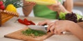 Close-up of human hands cooking vegetables salad in kitchen. Healthy meal and vegetarian concept Royalty Free Stock Photo