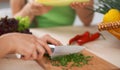 Close-up of human hands cooking vegetables salad in kitchen. Healthy meal and vegetarian concept Royalty Free Stock Photo