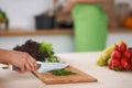 Close-up of human hands cooking vegetables salad in kitchen. Healthy meal and vegetarian concept Royalty Free Stock Photo