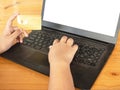 Close-up human hands holding a credit card and using computer. o Royalty Free Stock Photo