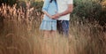 Close up of human hands holding pregnant belly, closeup happy family awaiting baby, standing on green grass, body part, young fami