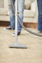 Close up of human legs and vacuum cleaner at home Royalty Free Stock Photo