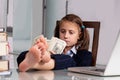 Close up humorous portrait of happy cute young business girl counts money profit with bare feet on the table. Selective focus on Royalty Free Stock Photo