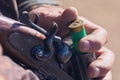 Close up of hunter loading shotgun, .holds a gun and ammunition