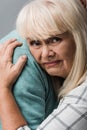 close up of husband hugging sad retired wife with grey hair isolated on grey. Royalty Free Stock Photo