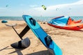 Close-up hydrofoil surf board and kite equipment on sand beach shore watersport spot on bright sunny day against sea Royalty Free Stock Photo