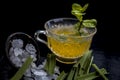 Close up of Iced lemon grass tea in a transparent cup on wooden surface with raw lemon grass green tea in a cup and sugar in a cla Royalty Free Stock Photo